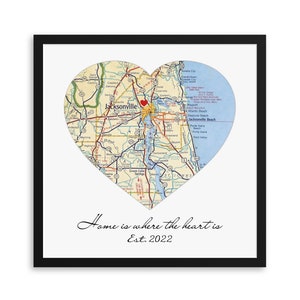 May include: A black framed print with a heart-shaped map of Jacksonville, Florida. The map is in vintage style and features roads, rivers, and landmarks. The text "Home is where the heart is Est. 2022" is printed below the map.