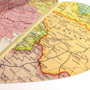 May include: A vintage map of Lithuania, Latvia, and parts of Poland. The map is printed on yellowed paper and features a faded red, green, and blue color scheme. The map includes city names and borders.