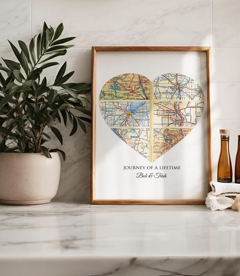 May include: A framed print with a heart-shaped collage of vintage maps. The text below the map reads "Journey of a Lifetime Bob & Trish".