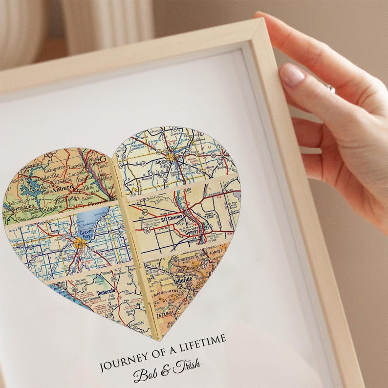 A custom map print with several map locations and personalized text with the couples names and dates for when they met, got engaged, married and their wedding anniversary. The customizable wall art is in the shape of a heart and made with vintage maps.