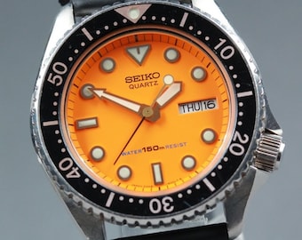 SEIKO 6458-600A Reloj de hombre con fecha/día, esfera naranja, resistente al agua hasta 150 m, movimiento de cuarzo, 38 mm, 1982
