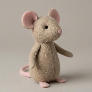 May include: A handmade stuffed mouse toy with a light brown body, pink ears, nose, and feet. The mouse has black eyes and long whiskers. The toy is made of soft fabric and has a whimsical, friendly appearance.