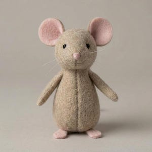 Könnte beinhalten: Ein handgefertigtes Stoffmaus-Spielzeug mit einem hellbraunen Körper, rosa Ohren, Nase und Füßen. Die Maus hat schwarze Knopfaugen und lange weiße Schnurrhaare. Das Spielzeug steht aufrecht mit leicht ausgestreckten Armen.