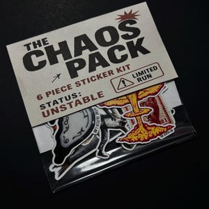 Pode incluir: Um kit de autocolantes intitulado "The Chaos Pack" com seis peças. A embalagem é bege claro com texto preto. Os autocolantes apresentam vários gráficos, incluindo um relógio, uma figura e uma nuvem de cogumelos. O texto "Limited Run" também é visível.