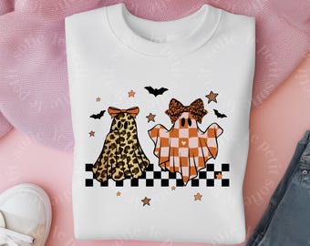 May include: White sweatshirt featuring two ghost illustrations with bows. One ghost has a leopard print design, and the other has an orange and white checkered pattern. The design includes bats and stars on a black and white checkered border.