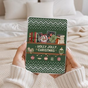 May include: A green tablet case with a festive Christmas design. The case features a shelf with books, ornaments, and the text "Holly Jolly Christmas." The top has a white knit pattern, and the bottom has hanging ornaments.