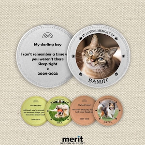 May include: A selection of pet memorial keepsakes. The keepsakes are circular, with a silver border and various designs. One features a cat named Bandit, another a dog named Max, and another a dog named Hazel. Each has a photo and text.