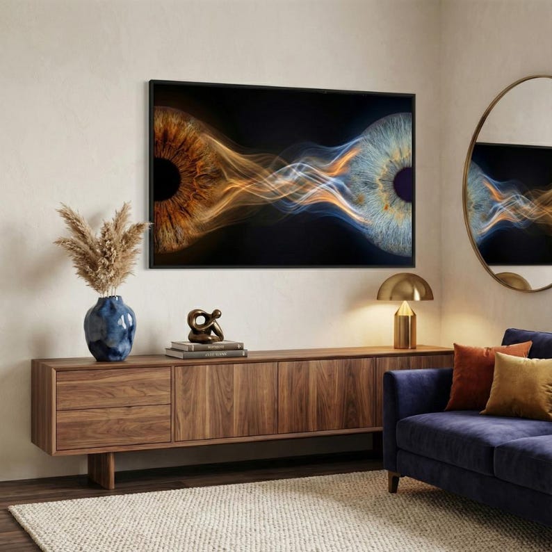 May include: A rectangular wall art piece featuring a high-contrast macro image of two human irises, one brown and one blue, connected by flowing golden and white light streaks against a black background, framed in a thin black border.