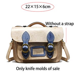 Puede incluir: Bolso de cuero beige con detalles azules y hebillas de lat&oacute;n. El bolso, de aproximadamente 22 x 15 x 6cm, tiene un asa superior y un bolsillo frontal rectangular. El texto "Only knife molds of sale" es visible.