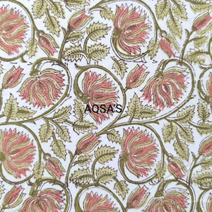 K&ouml;nnte beinhalten: Wei&szlig;er Stoff mit einem sich wiederholenden Blumenmuster aus rosa Bl&uuml;ten, gr&uuml;nen Bl&auml;ttern und Stielen. Der Text "AQSA'S" ist in Schwarz gedruckt. Geeignet f&uuml;r Textilien oder Heimdekoration.