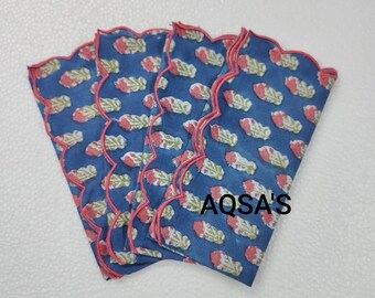 Pode incluir: Uma pilha de guardanapos de tecido azuis com um padrão floral em vermelho e branco. Cada guardanapo tem uma borda ondulada com acabamento em vermelho. O texto "AQSA'S" é visível no canto inferior direito.