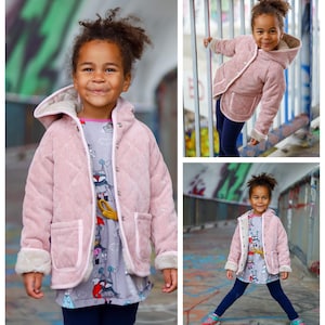 May include: A young girl wearing a pink corduroy jacket with a white fur trim and a grey and white patterned shirt. The jacket has a hood and two pockets. The girl is smiling and looking at the camera.