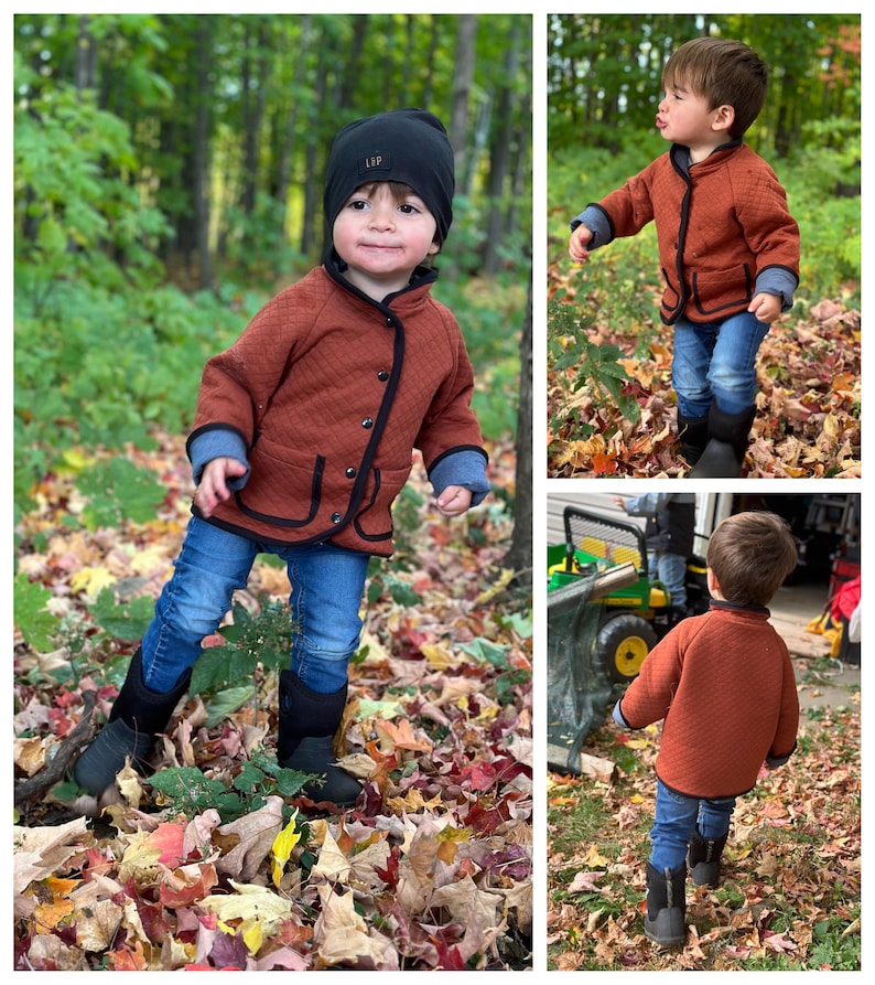 May include: A young child wearing a brown quilted jacket with black trim, blue jeans, and black boots. The child is standing in a pile of autumn leaves.