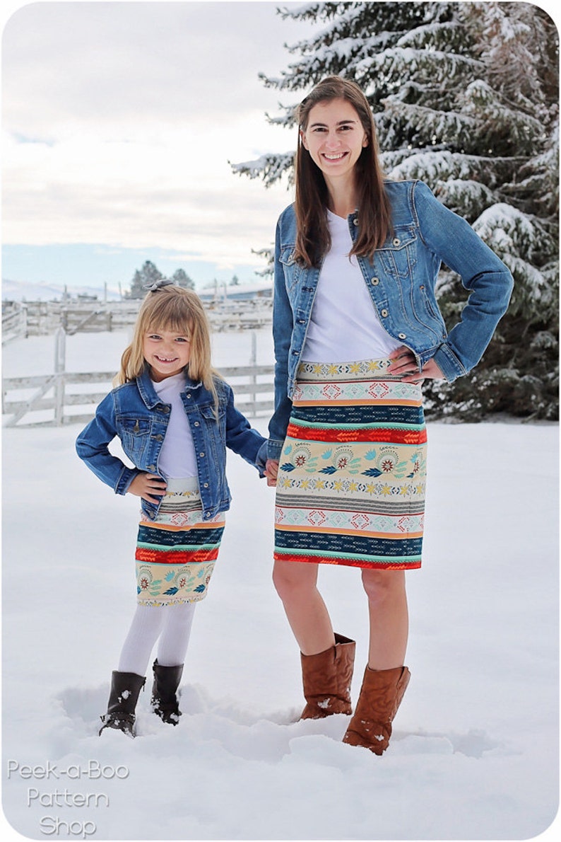 Puede incluir: Dos personas con chaquetas vaqueras y faldas de estampado colorido est&aacute;n de pie en la nieve. Las faldas tienen un dise&ntilde;o geom&eacute;trico con rayas y motivos florales. La persona de la izquierda es una ni&ntilde;a, y la persona de la derecha es una adulta. El texto "Peek-a-Boo Pattern Shop" est&aacute; en la parte inferior de la imagen.