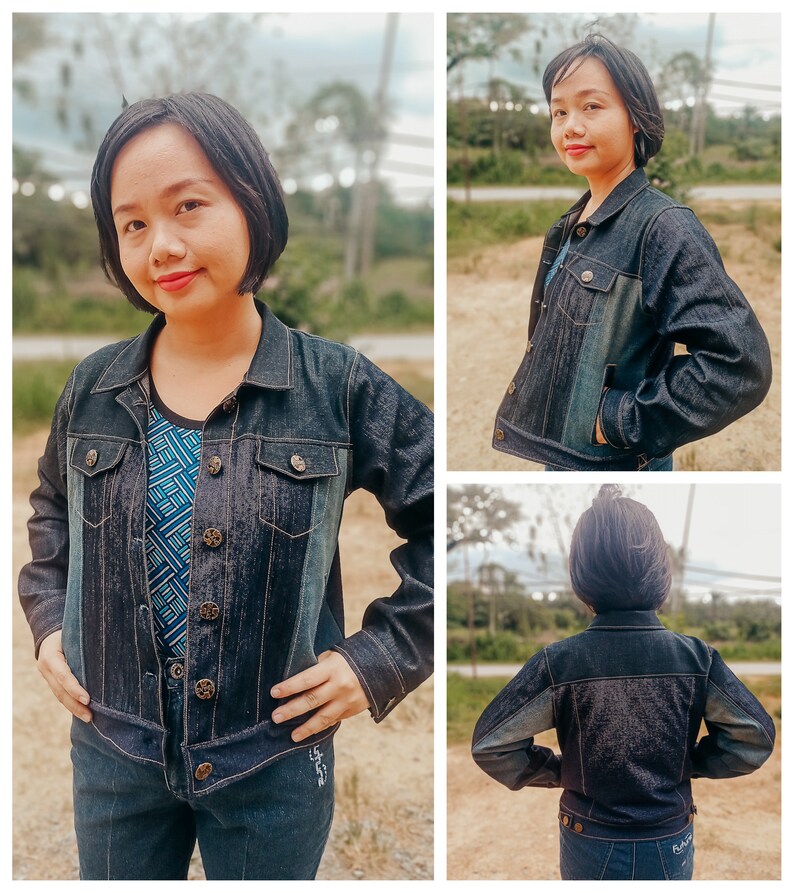 May include: A dark blue denim jacket with button closures and pockets. The jacket is worn with a patterned top and matching jeans. The jacket has a classic collar and long sleeves. The denim jacket is a versatile piece of clothing.