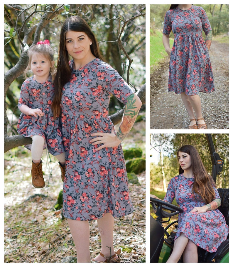 Pode incluir: Duas pessoas vestindo vestidos combinando com estampa floral. O vestido &eacute; cinza com flores rosa e vermelhas. O vestido tem mangas curtas e um decote redondo. O vestido &eacute; at&eacute; o joelho. As pessoas est&atilde;o em p&eacute; em uma &aacute;rea arborizada.