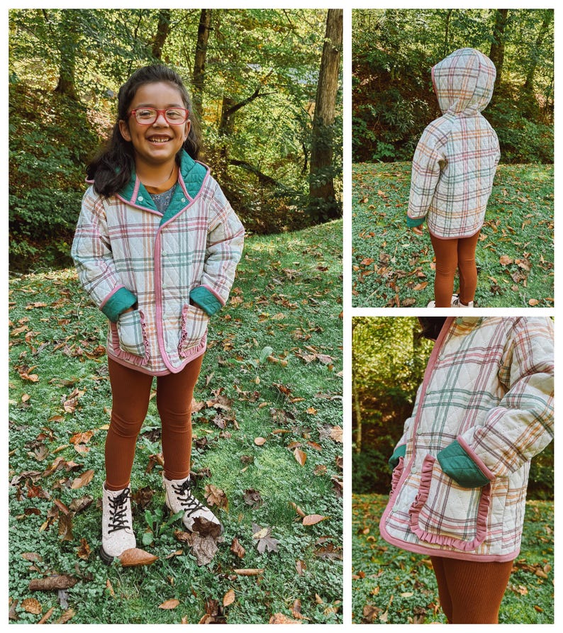 May include: A child wearing a plaid quilted jacket with a green hood and brown leggings. The jacket has a ruffled trim and a pocket on each side. The child is standing in a grassy area with autumn leaves on the ground.