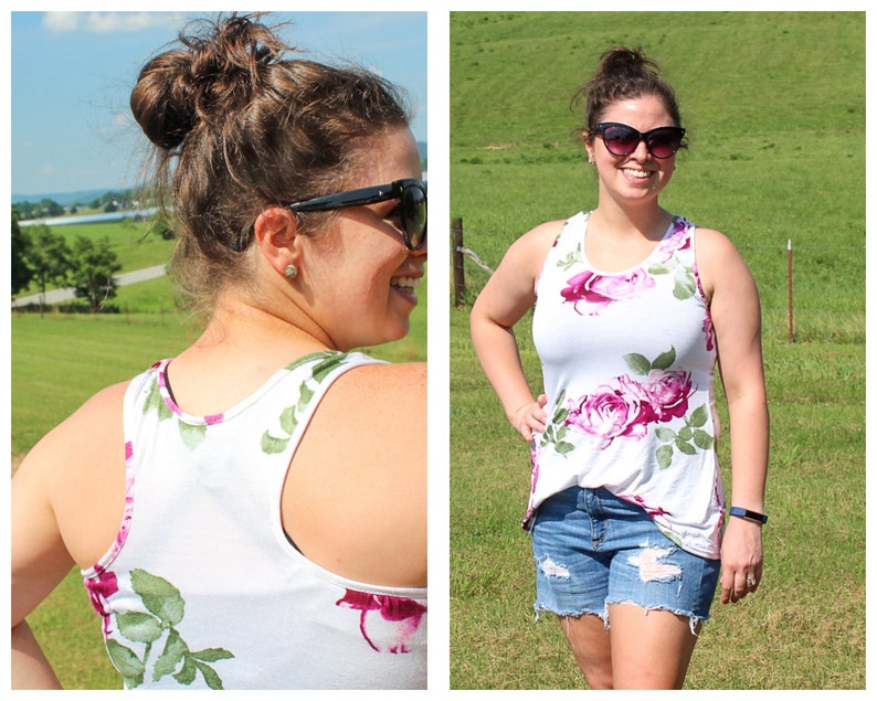 May include: A white tank top with a floral print featuring pink roses and green leaves. The tank top has a scoop neck and a racerback style.