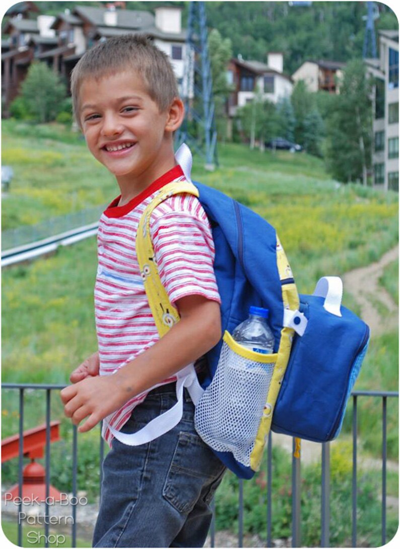 May include: A young person wearing a red and white striped shirt with a blue and yellow backpack. The backpack has a mesh side pocket with a clear water bottle inside.