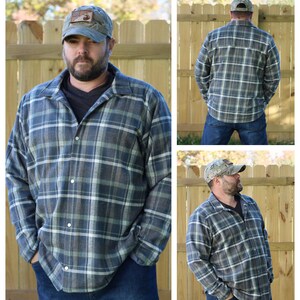May include: A blue and green plaid flannel shirt with a button-up front and long sleeves. The shirt is worn by a person with a beard and a camouflage baseball cap.