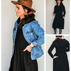 Pode incluir: Um vestido preto com capuz e saia franzida. O vestido &eacute; usado com uma jaqueta de ganga e um chap&eacute;u fedora castanho.