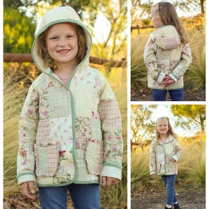 May include: A child wearing a green and white quilted jacket with a hood. The jacket has a patchwork design with floral and geometric patterns. The child is standing in a field of long grass.