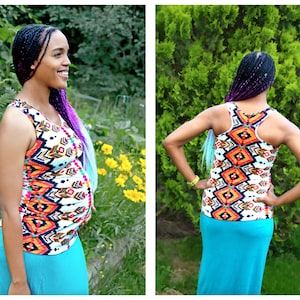 May include: A woman wearing a white tank top with a colorful geometric pattern and a turquoise maxi skirt. She has long purple and blue braids.