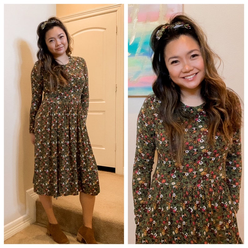 Pode incluir: Uma mulher vestindo um vestido midi verde floral com mangas compridas e decote redondo. Ela est&aacute; usando botas de tornozelo marrons e tem uma faixa de cabelo.