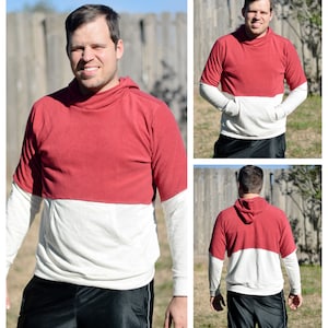 May include: A red and white long-sleeved hooded sweatshirt with a kangaroo pocket. The sweatshirt has a contrasting colour block design.