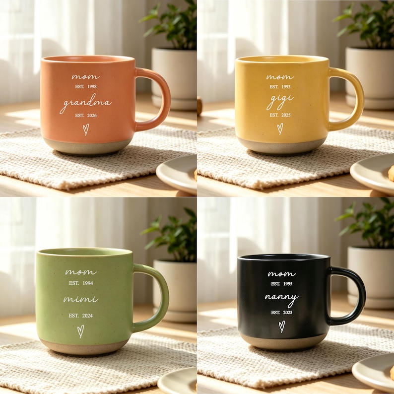 Puede incluir: Cuatro tazas de cer&aacute;mica en tonos naranja, amarillo, verde y negro. Cada taza tiene una base y un asa de color crema. Las tazas est&aacute;n inscritas con la palabra "mam&aacute;" y un t&eacute;rmino de cari&ntilde;o, junto con el a&ntilde;o de establecimiento y un s&iacute;mbolo de coraz&oacute;n.