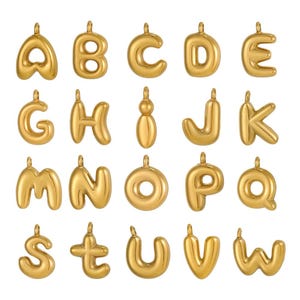 May include: A collection of gold-colored alphabet pendants, each with a loop for hanging. The letters A, B, C, D, E, G, H, I, J, K, M, N, O, P, Q, S, T, U, V, and W are displayed.