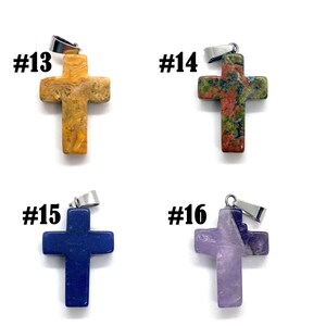 May include: Four gemstone cross pendants with silver-tone bails. The crosses are in shades of yellow, green, red, blue, and purple. Each pendant is labeled with a number from #13 to #16.