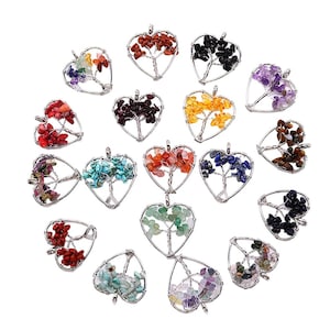 Puede incluir: Una colección de colgantes en forma de corazón con un diseño de árbol, elaborados con alambre plateado y piedras preciosas de colores. Las piedras preciosas son de varios colores, incluyendo rojo, verde, azul y morado. Los colgantes están sobre un fondo blanco.