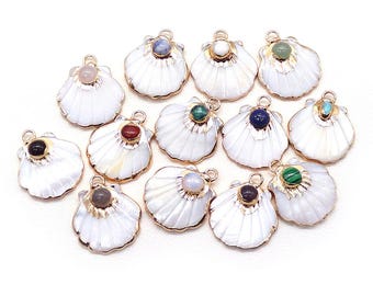 May include: A collection of white seashell charms with gold-colored trim and various gemstone accents. Each charm features a different colored gemstone, including pink, blue, green, and brown. The charms are arranged on a white background.