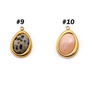 May include: Two teardrop-shaped pendants with gold-colored metal frames. One pendant features a speckled gray stone, and the other has a light pink stone. The pendants are labeled with the numbers #9 and #10.