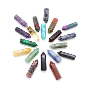 May include: A collection of various gemstone crystal wands arranged in a circular pattern. The wands are in a variety of colors, including purple, green, blue, and red. Each wand is approximately 3 inches long.