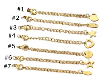 May include: Gold-colored necklace extenders with lobster claw clasps. Seven different styles are shown, including heart, star, and round charm designs. Each extender is labeled with a number from #1 to #7.
