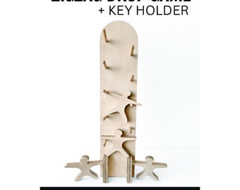 May include: A wooden zigzag drop game and key holder. The game features a tall, light-colored wooden board with pegs and cut-out human figures. The text "ZIGZAG DROP GAME + KEY HOLDER" is at the top. The bottom text reads "WOODWORKING CNC PLAN Includes DXF + DWG + STP".