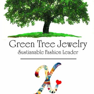 The image is a promotional poster for a jewelry brand called "Green Tree Jewelry". It features a large green tree with a heart symbol in the center, and the text "Green Tree Jewelry Sustainable Fashion Leader" is displayed above the tree. The poster also mentions a "Frage X Awareness Mission Leading Inherited Cause of Autism".