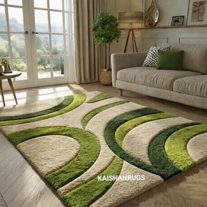 May include: A beige and green area rug with a wavy, abstract design. The rug features varying shades of green and beige, creating a textured, three-dimensional effect. The text "KAISHANRUGS" is visible on the rug.