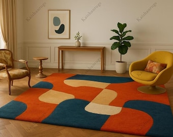 May include: A modern area rug with an abstract design in shades of orange, teal, and cream. The rug is rectangular and features a bold, geometric pattern. The room also includes a yellow chair, wooden furniture, and a potted plant.