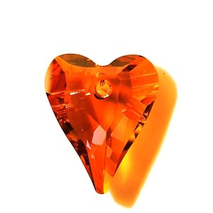 May include: A faceted, orange heart-shaped crystal pendant. The crystal is transparent, allowing light to pass through and create a brilliant shine. The pendant has a small hole at the top for hanging. The heart shape is a classic symbol of love and affection.