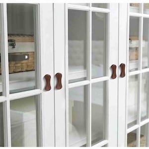 Puede incluir: Un juego de tres tazas de cerámica con un acabado mate moteado. Las tazas son de color crema, gris claro y gris oscuro. Cada taza tiene un diseño simple y minimalista y un asa redondeada.