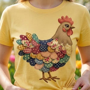 Può includere: T-shirt giallo con un design a patchwork di gallina colorata. La gallina ha un corpo marrone, una cresta rossa e una coda fatta di vari tessuti fantasia, tra cui fiori, pois e quadri. La maglietta è annodata in vita.