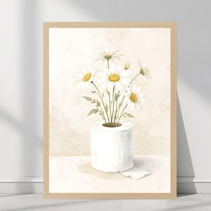 Könnte beinhalten: Aquarelldruck mit weißen Gänseblümchen mit gelben Zentren und grünen Blättern, angeordnet in einer Rolle weißem Toilettenpapier. Das Kunstwerk ist in einem hellbraunen Holzrahmen vor einem neutralen Hintergrund gerahmt.