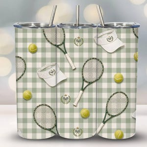 May include: A set of three stainless steel insulated tumblers with lids and straws. The tumblers feature a repeating pattern of tennis rackets, tennis balls, and visors on a green and white checkered background. A tennis-themed design.