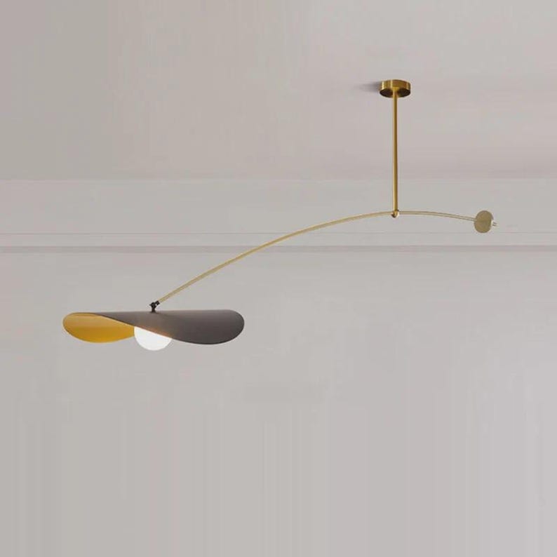 May include: Modern ceiling light fixture with a brass finish. The fixture features a curved arm with a gray and yellow shade and a spherical light bulb. The design is minimalist and elegant, suitable for contemporary interiors.