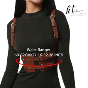May include: A brown leather harness with adjustable straps and buckles. The waist range is 69-82cm/27.16-32.28 inches. The harness is designed to be worn over clothing. The brand name "Knaughty Threads" is visible in the upper right corner.