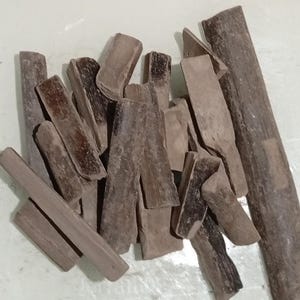 Pode incluir: Uma cole&ccedil;&atilde;o de pe&ccedil;as de madeira castanha de formato irregular. As pe&ccedil;as variam em tamanho e forma, algumas parecendo pequenas t&aacute;buas e outras mais parecidas com blocos. A madeira tem uma apar&ecirc;ncia natural e envelhecida.