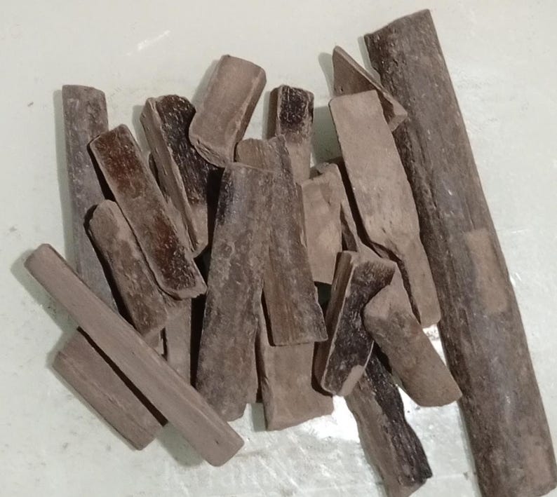 Pode incluir: Uma cole&ccedil;&atilde;o de pe&ccedil;as de madeira castanha de formato irregular. As pe&ccedil;as variam em tamanho e forma, algumas parecendo pequenas t&aacute;buas e outras mais parecidas com blocos. A madeira tem uma apar&ecirc;ncia natural e envelhecida.